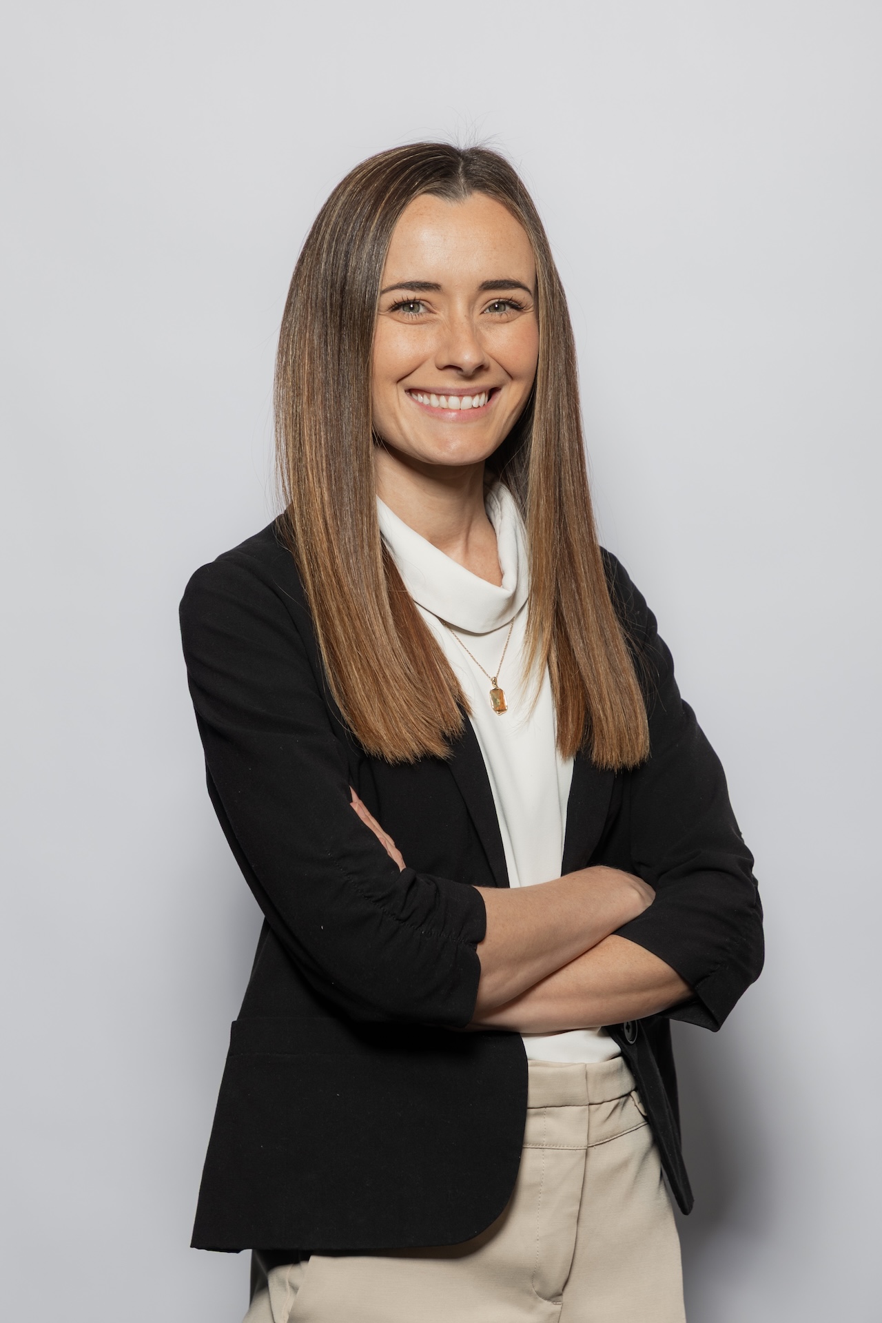 Kristy Doyle, a team member at Croy Legal, seated at her desk in an office environment, smiling and wearing glasses.